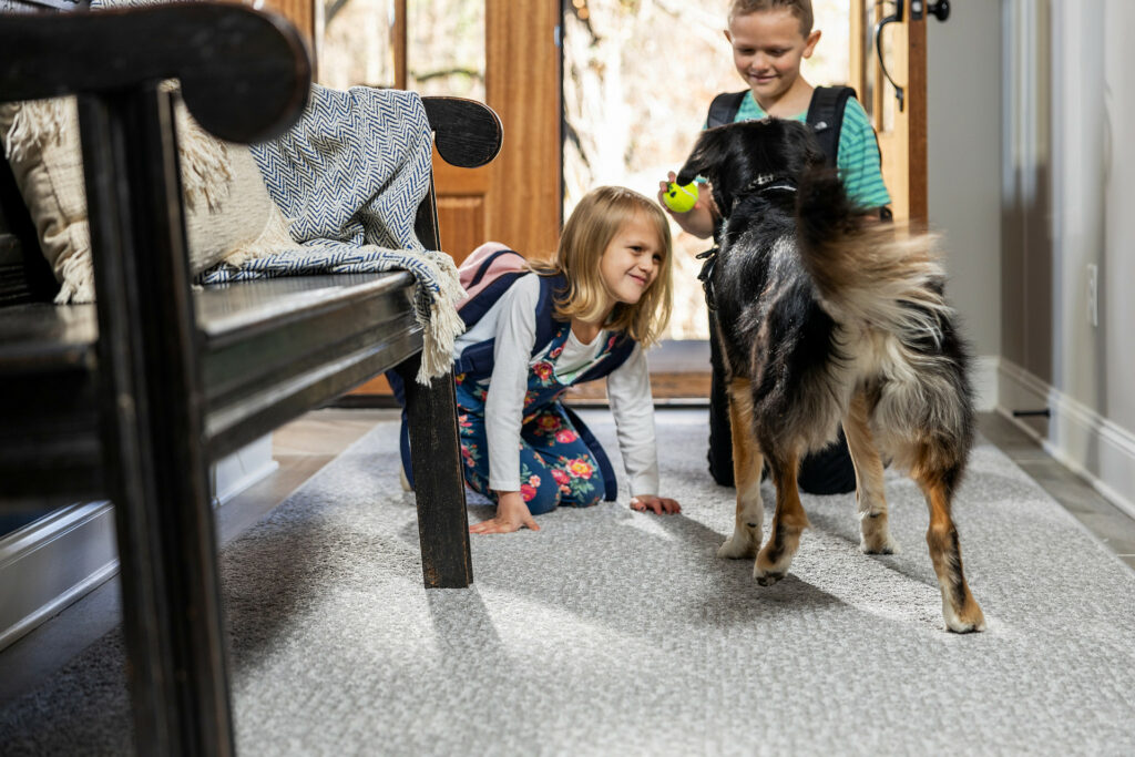 Kids playing with dog on carpet floors | Tish Flooring